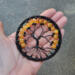 halloween style tree of life, created with black wire and nestled in black yarn wrapped metal hoop, decorated with orange crackle beads